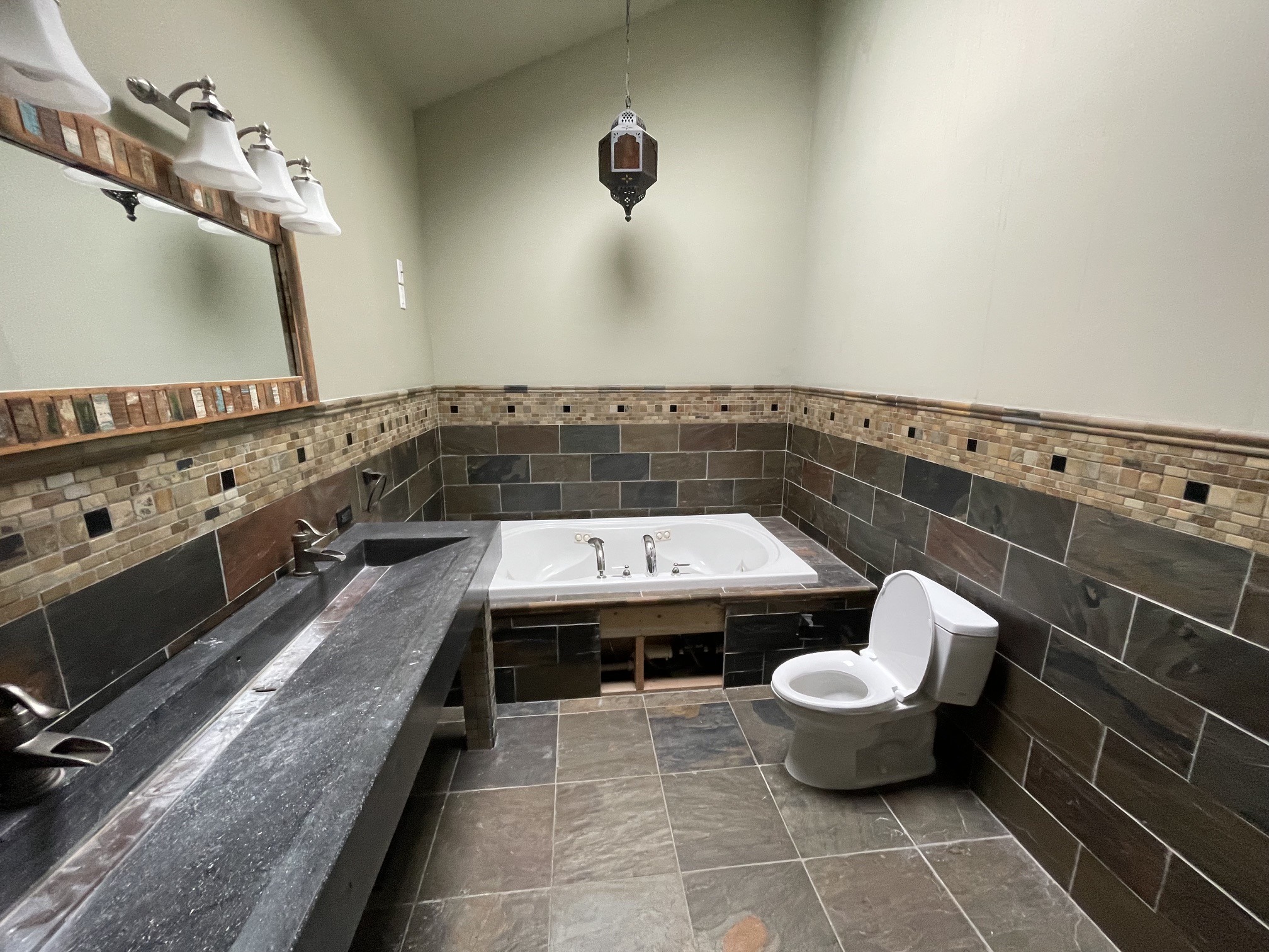 Chagrin Falls bathroom before renovation: Original jetted tub and dark tile