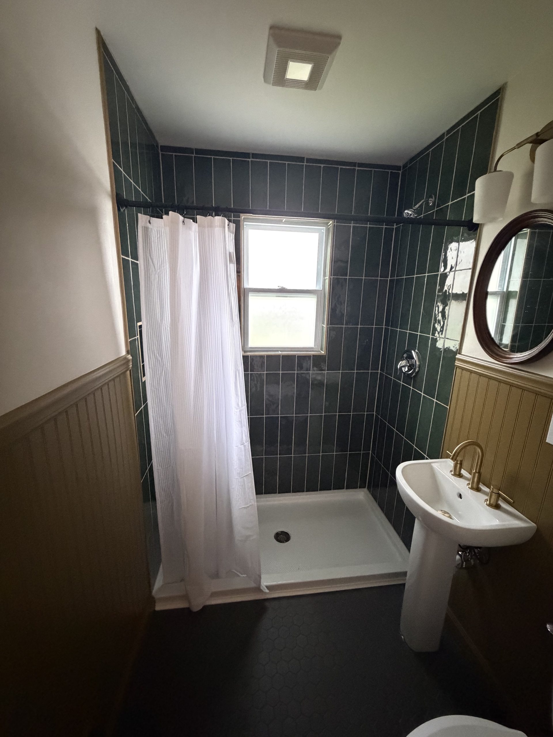 Kent bathroom with green tile shower and window