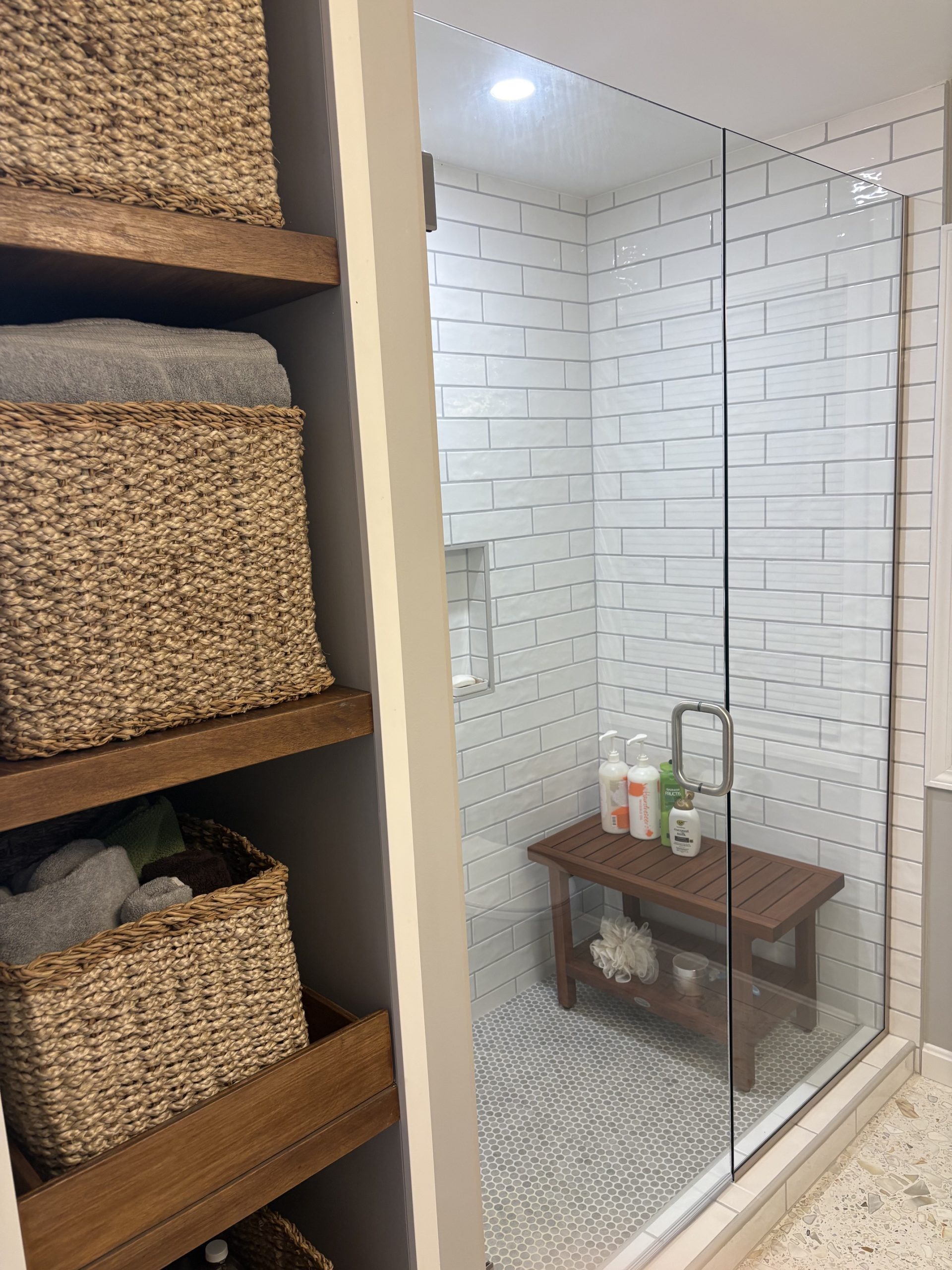 White subway tile shower and custom wood linen shelving in Shaker Heights