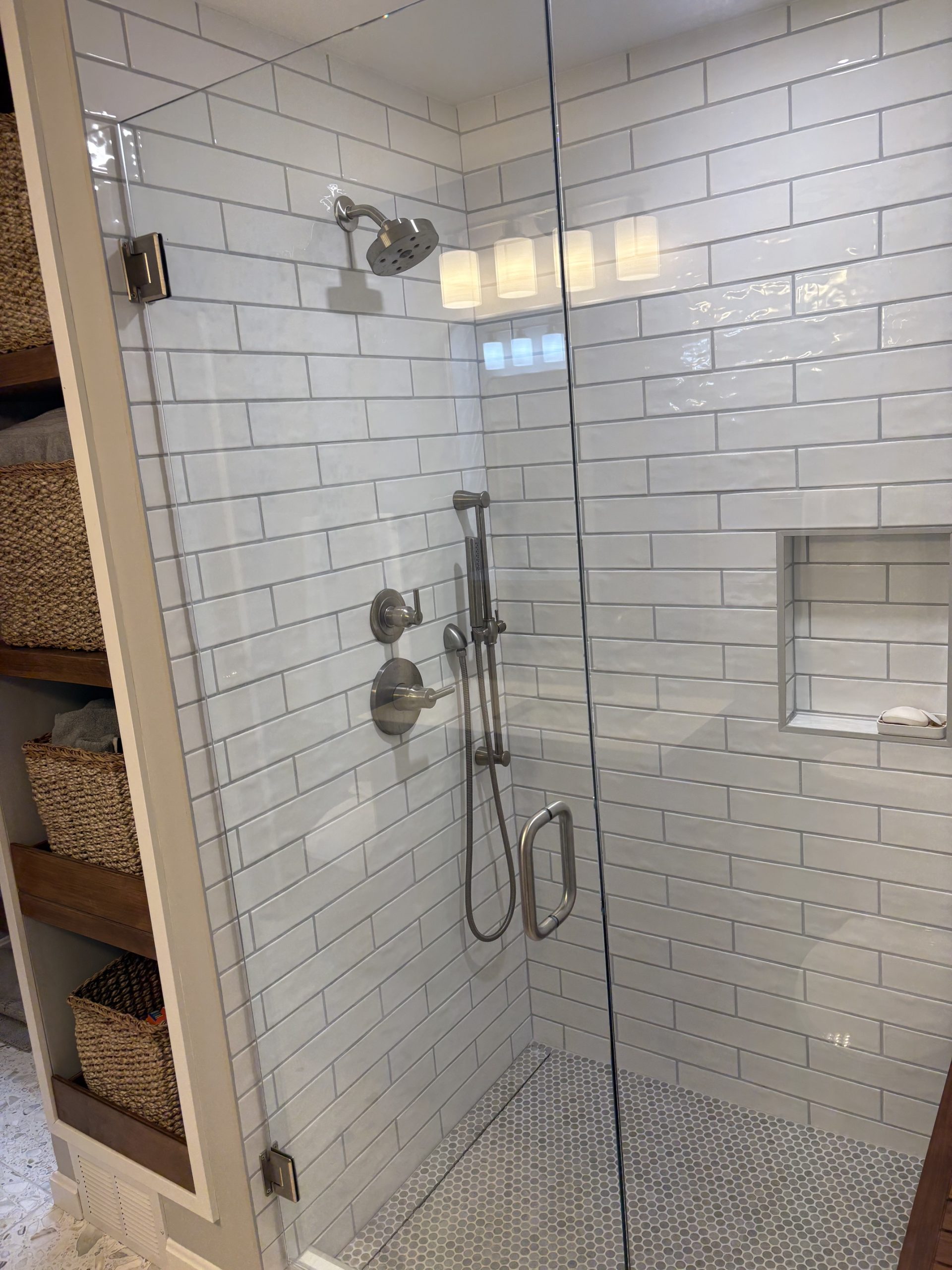 Glass shower with recessed niche, handheld shower and subway tile