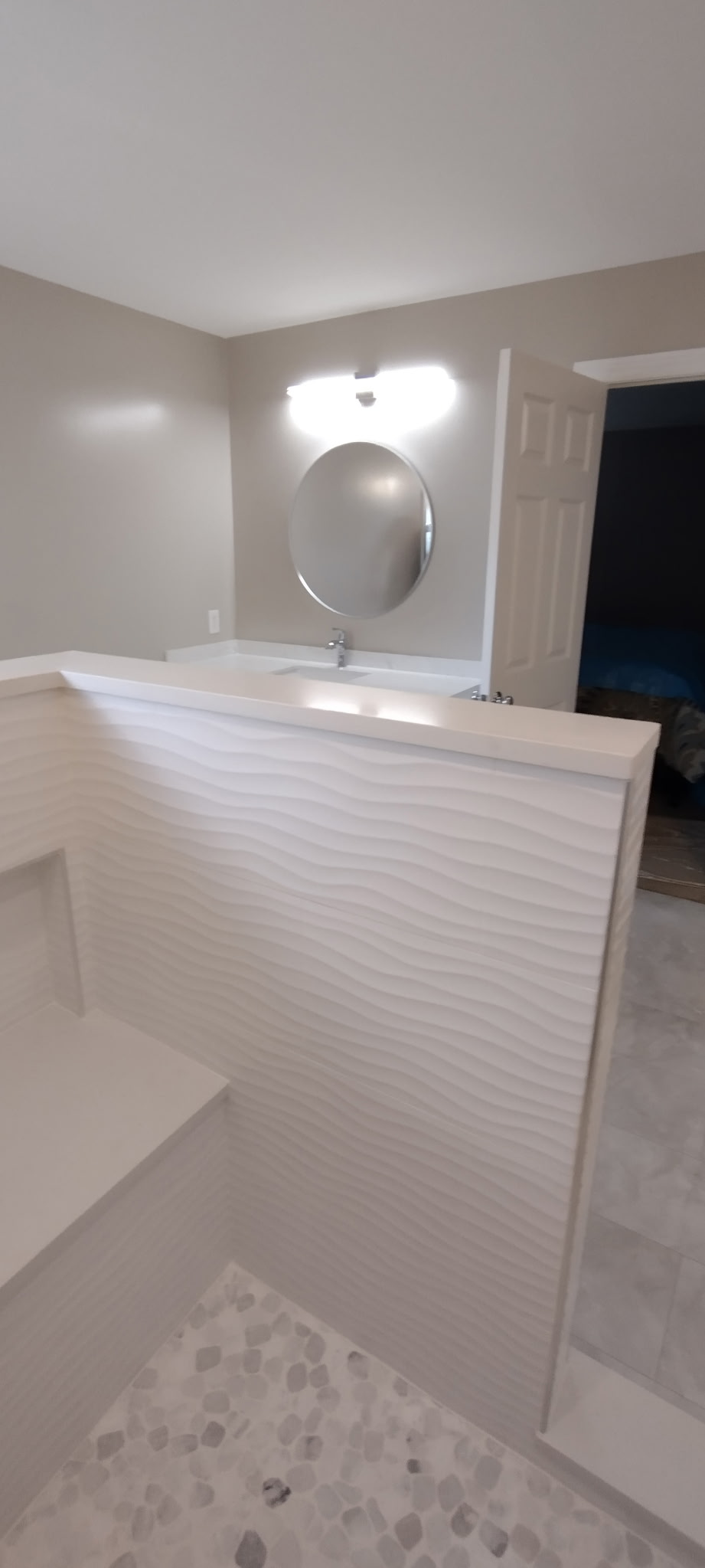 Sculpted wave tile on the shower half wall