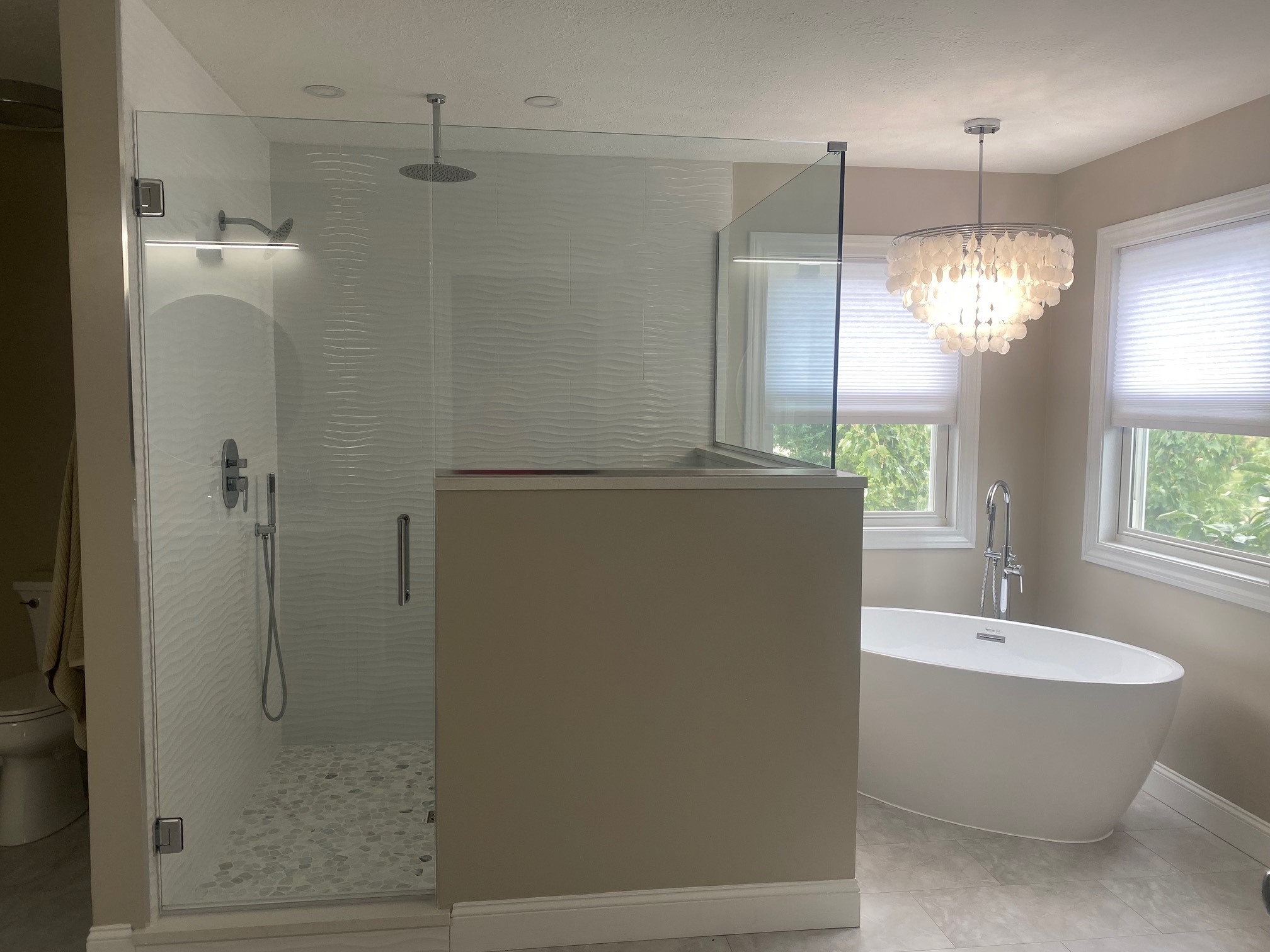 Completed bathroom with frameless glass shower and freestanding tub