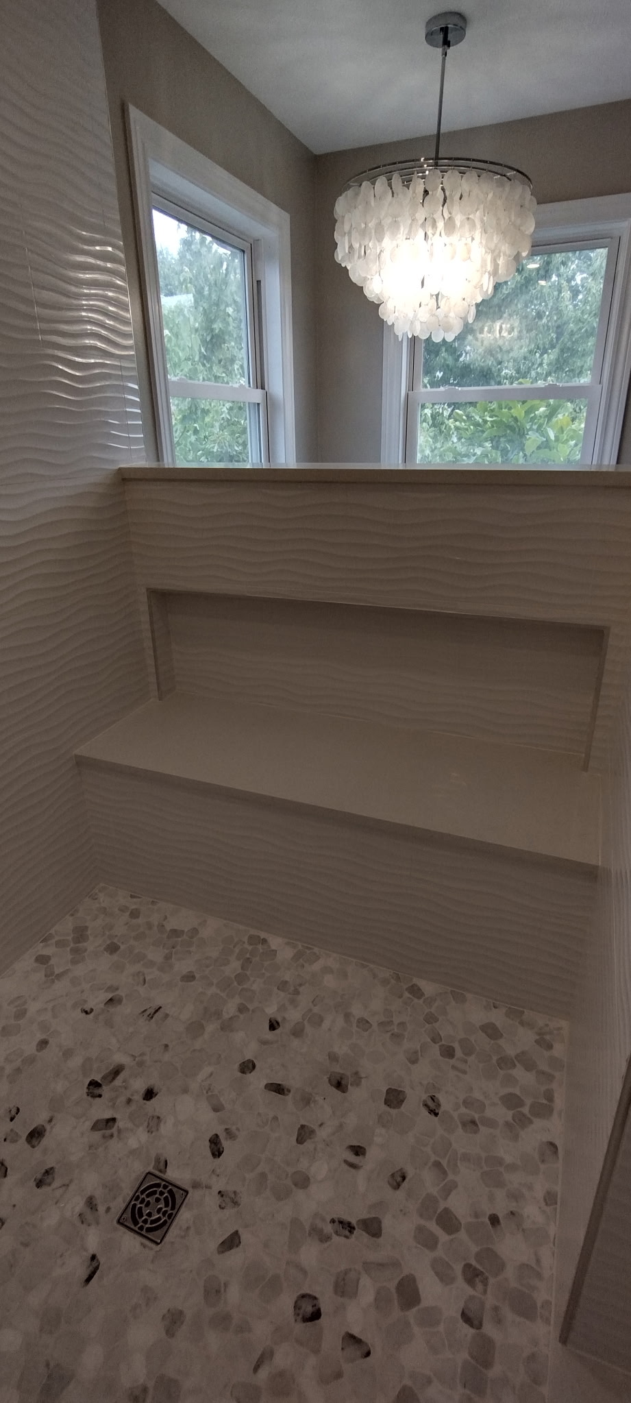 Pebble tile shower floor with built-in bench